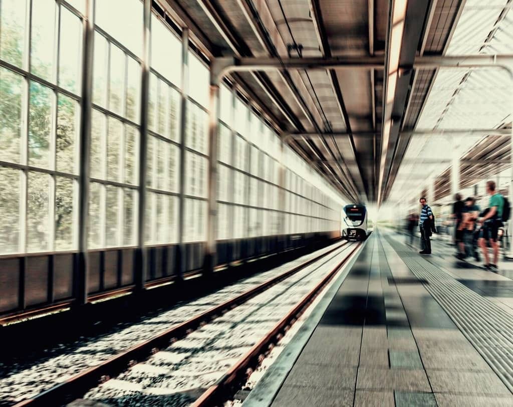 A train station with people waiting to board a train.