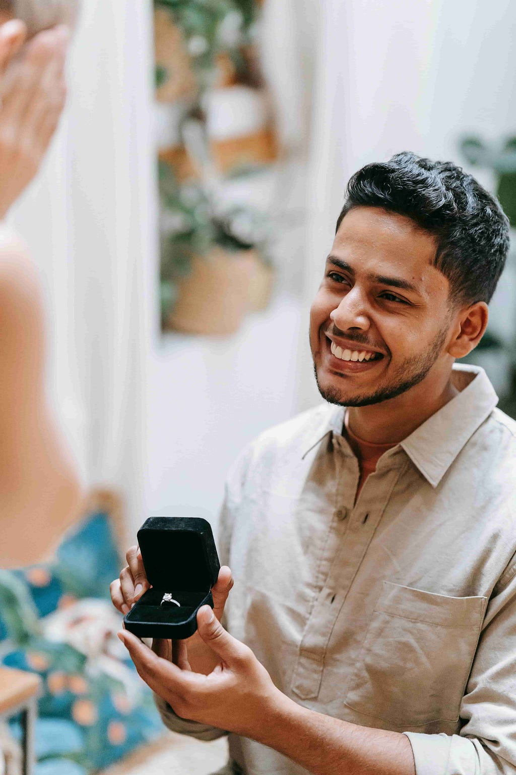 A man proposes with an engagement ring, showcasing an oval cut diamond ring suitable for everyday wear.