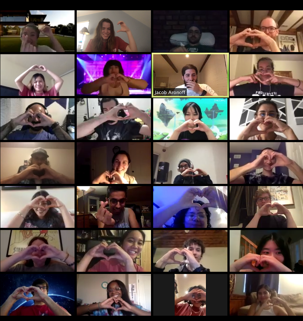 A screenshot of a 4-by-5 zoom meeting where each participant is making a hand heart. Most are are also smiling.