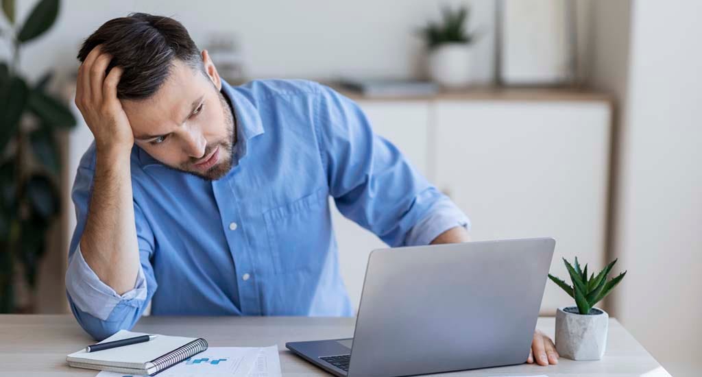 Entrepreneur sitting distressed in front of laptop