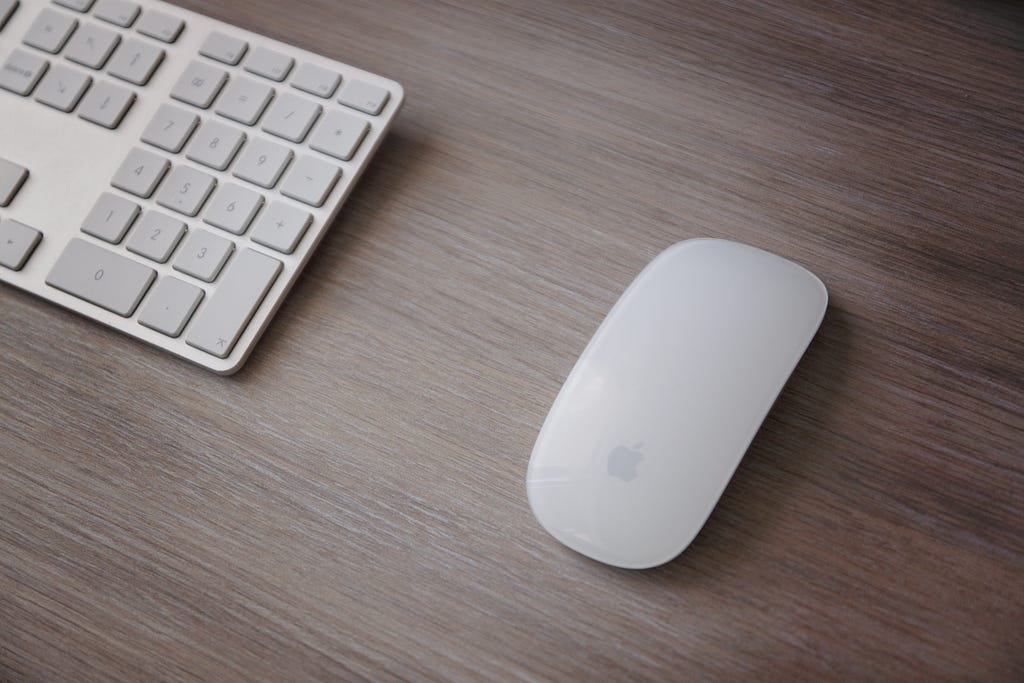 A mouse and keyboard on a wooden table