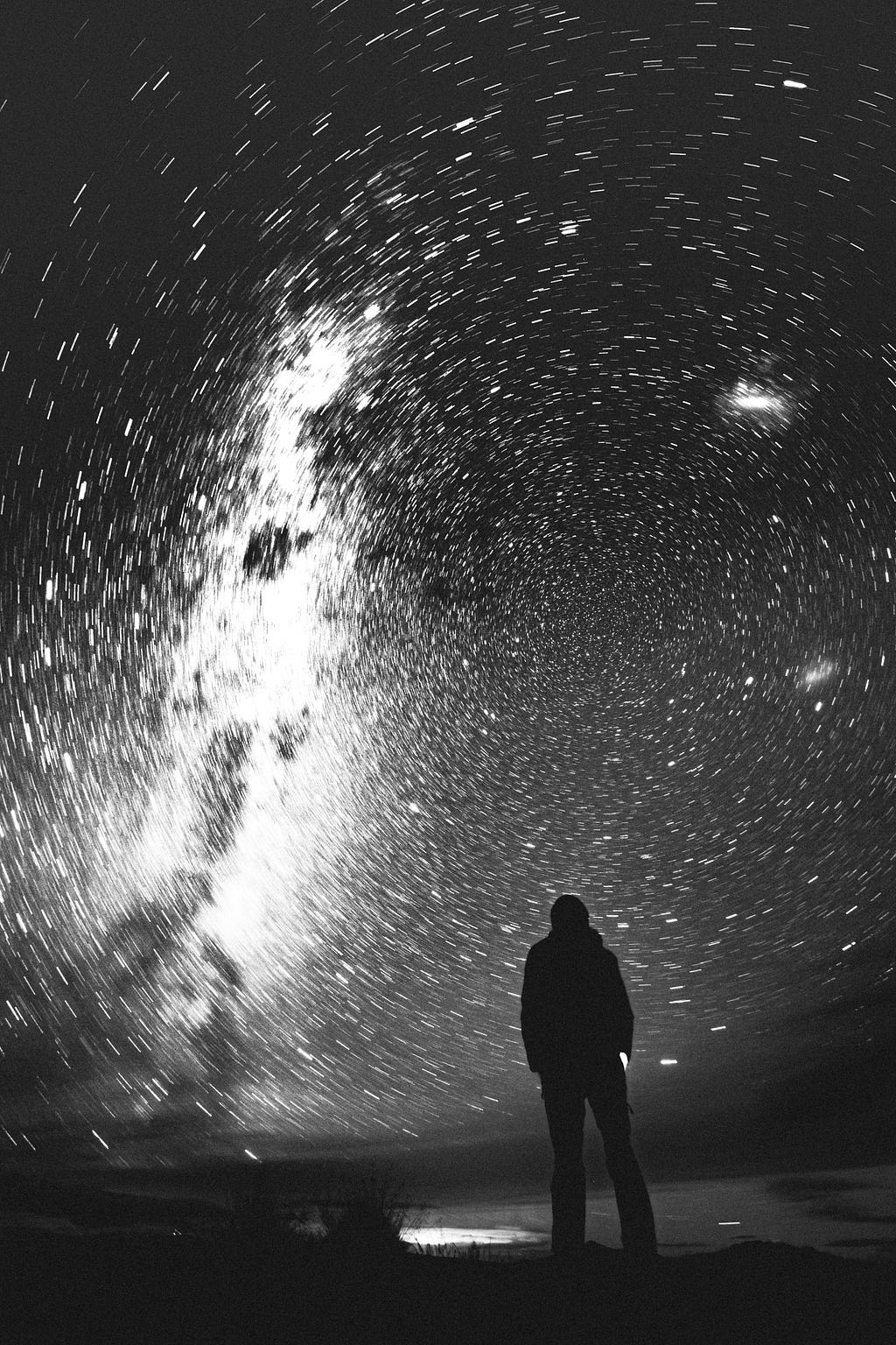 A shillouteed figure looks at a moving earth shot of the sky.