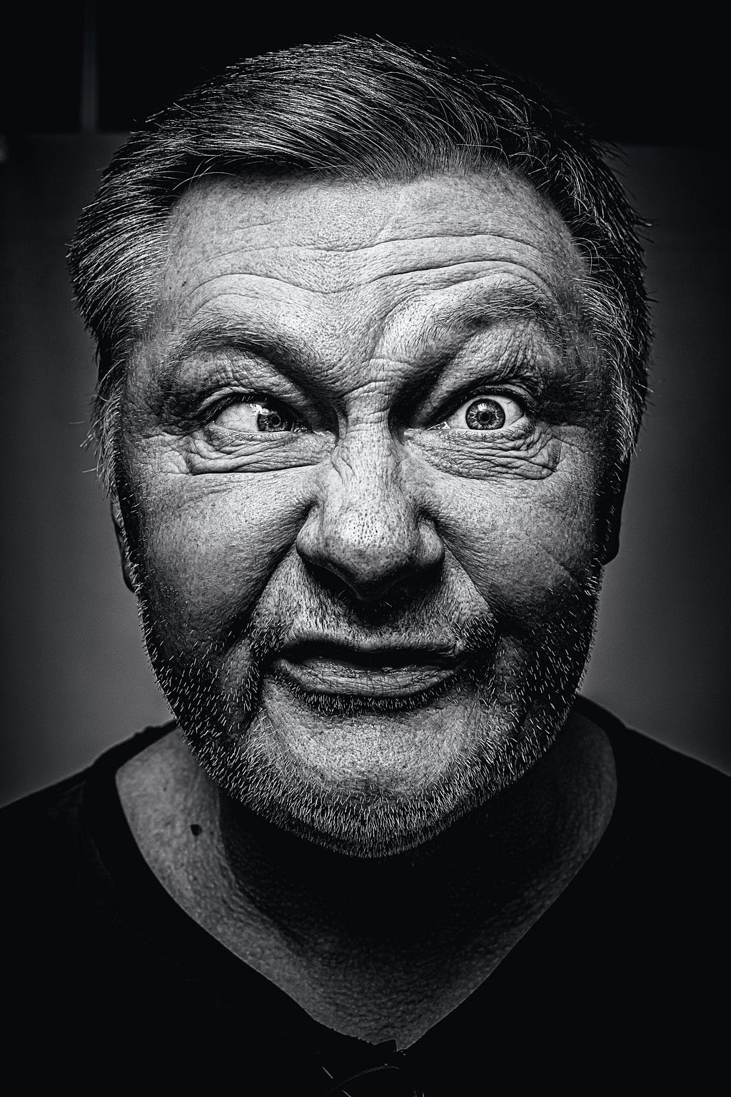A Black & White Portriate of an older man making a funny face