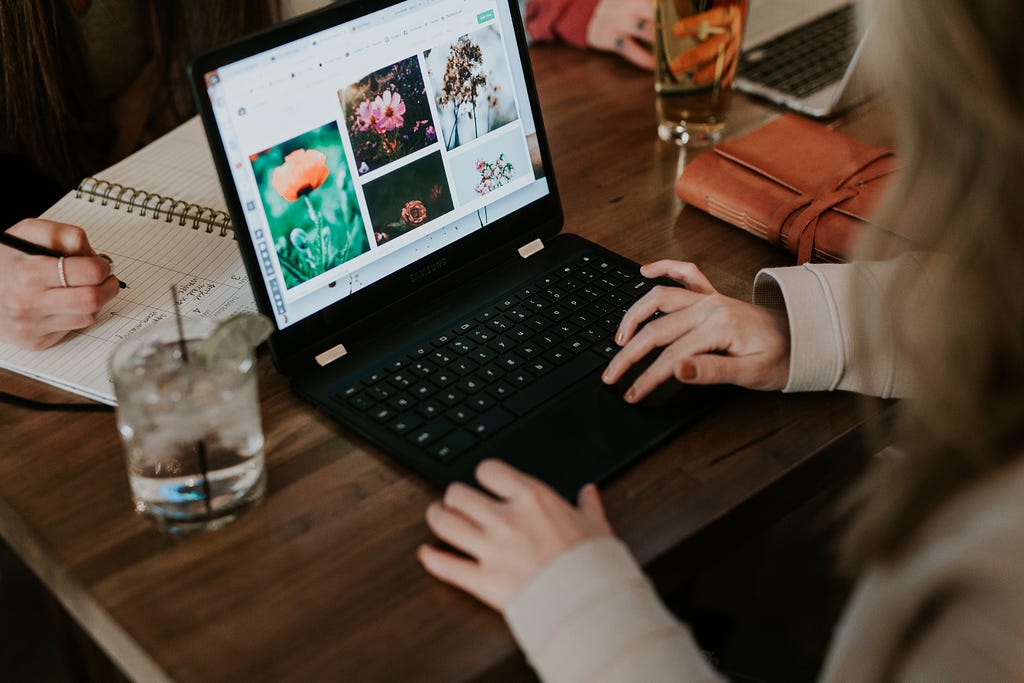 A group of people working on laptops while in a bar drinking