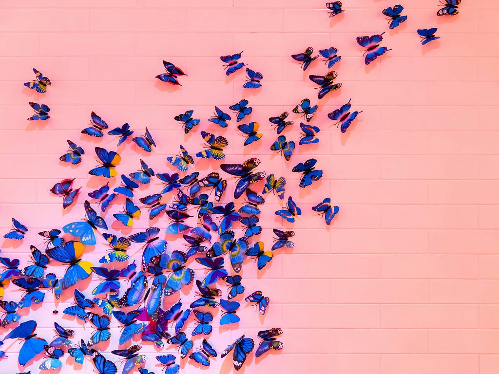 a group of purple butterflies splayed across a pink background
