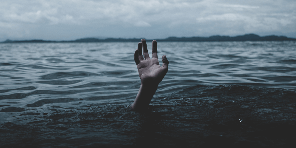 A person raising their hand from under water.