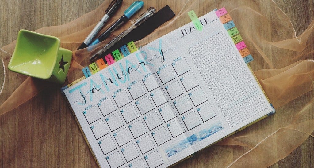 A planner and markers on a table