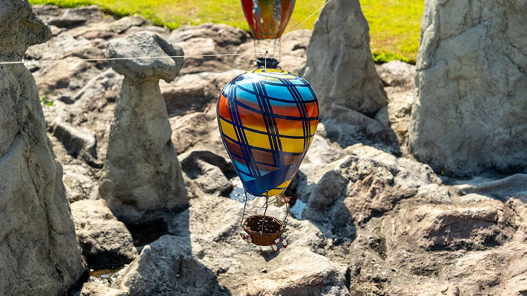 Small balloons are hung over an impromptu mountain range in the central part of the park