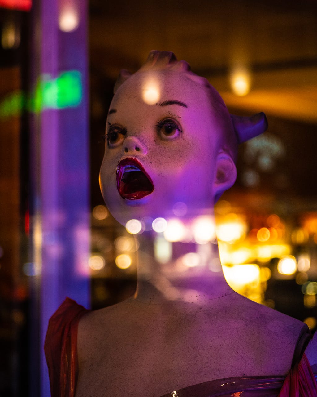 Mannequin with a stunned expression, staring up at lights