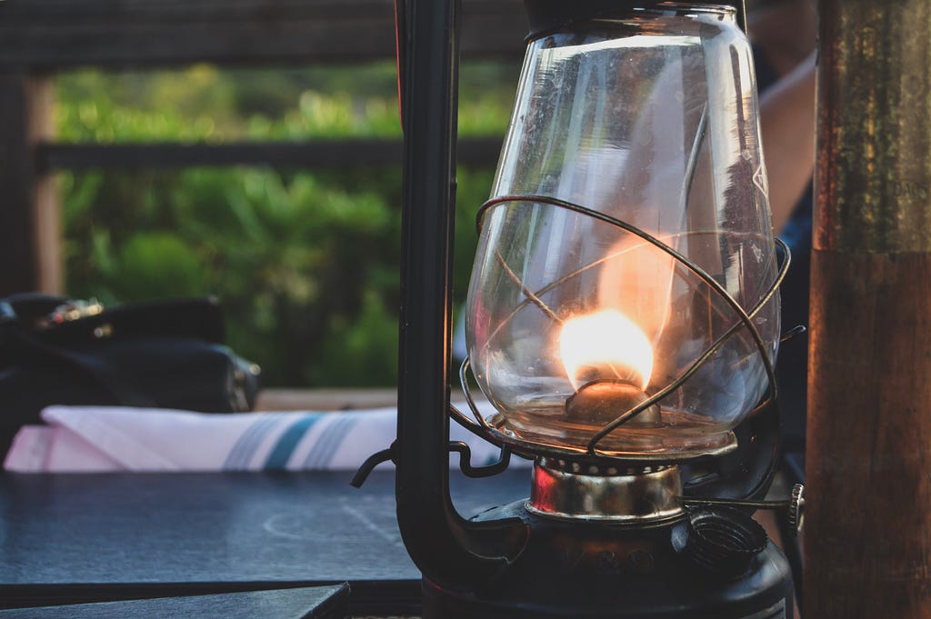 A lit oil lamp on a table