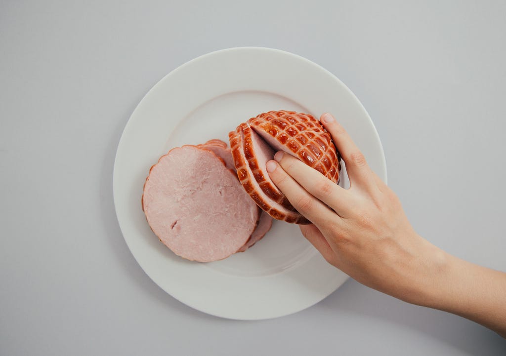 photo of hand with two fingers entering a should of pork to indicate a sexual act