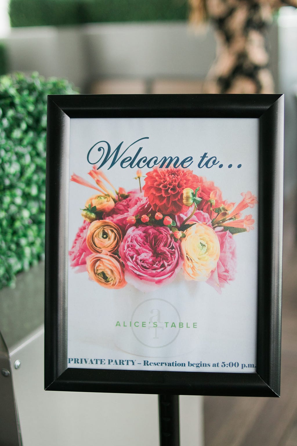 sign with flowers and text: Welcome to Alice's Table - Private Party - Reservation begins at 5:00pm