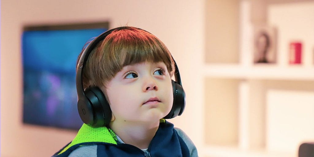 Autistic boy wearing headphones in order to prevent over-stimulation.