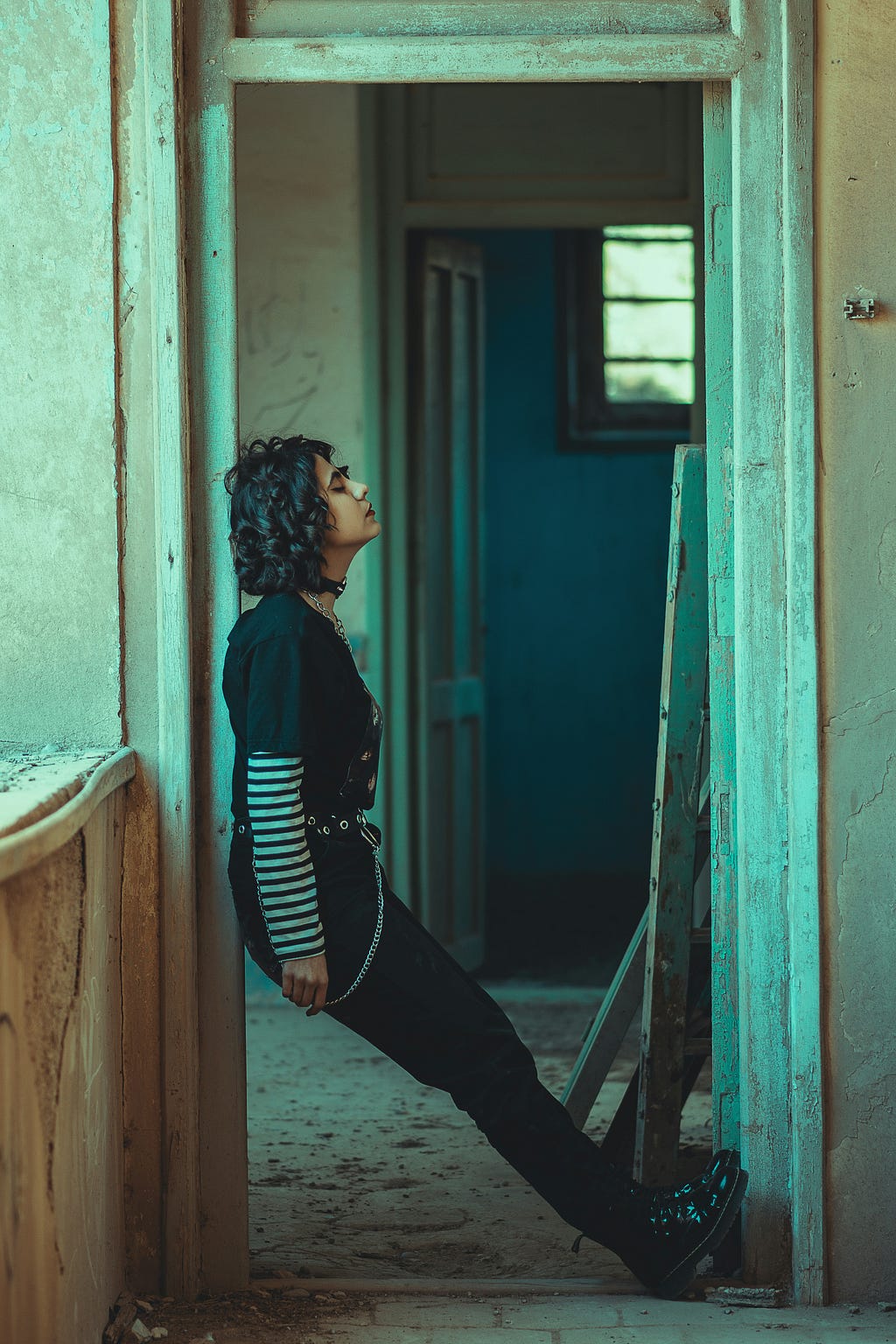 A depressed young woman leaning against a door