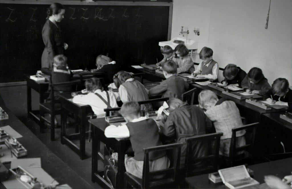 Children with their teacher in a class of primary school