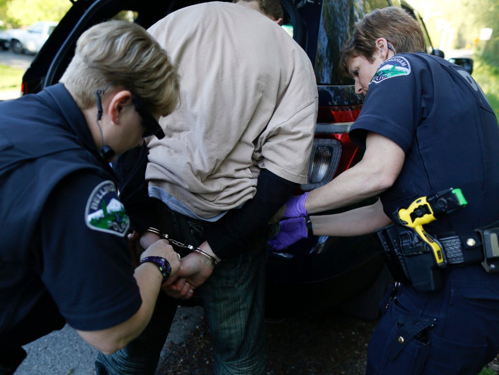 While responding to a welfare check on Northwest Ave, Officer Andria Fountain updates Bellingham Police Department Dispatch of the reported individual's status and identification from a call that came in describing a person lying on the ground outside of a gas station on April 25, 2015. Bellingham Police Department officers have to choose to start recording situations with their body cameras (seen here attached to Officer Fountain's sunglasses), however, Fountain says that she records most scenarios given constant unpredictability. 