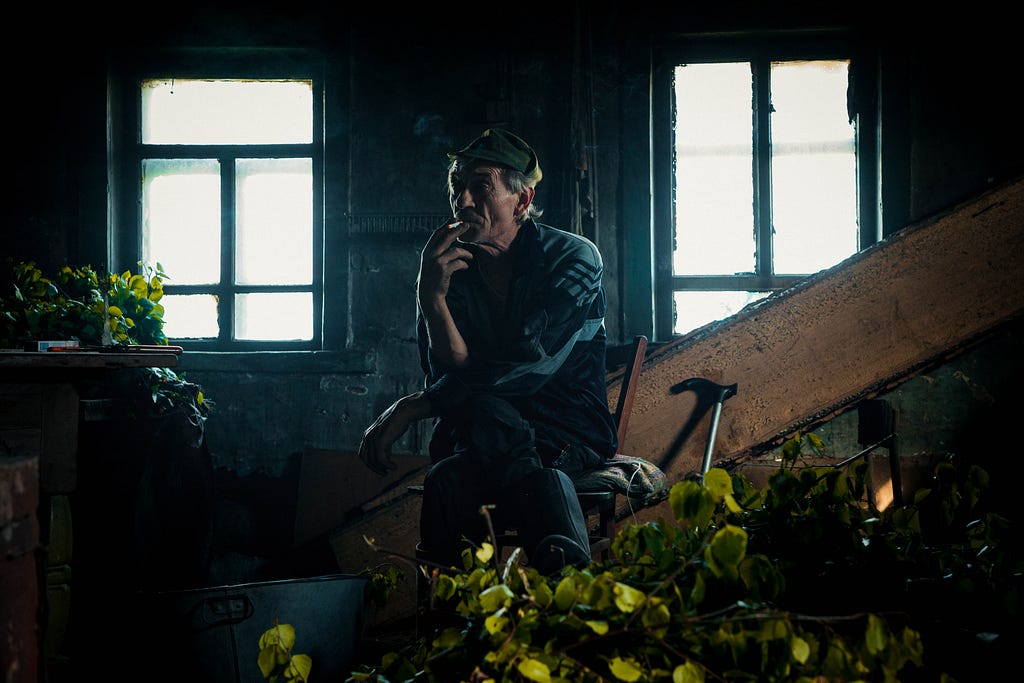 old man sitting smoking a cigarette