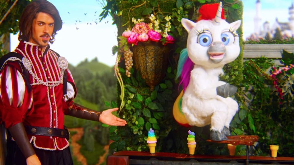 A photo of a still image of the Squatty Potty commercial with a man pointing to a unicorn pooping.