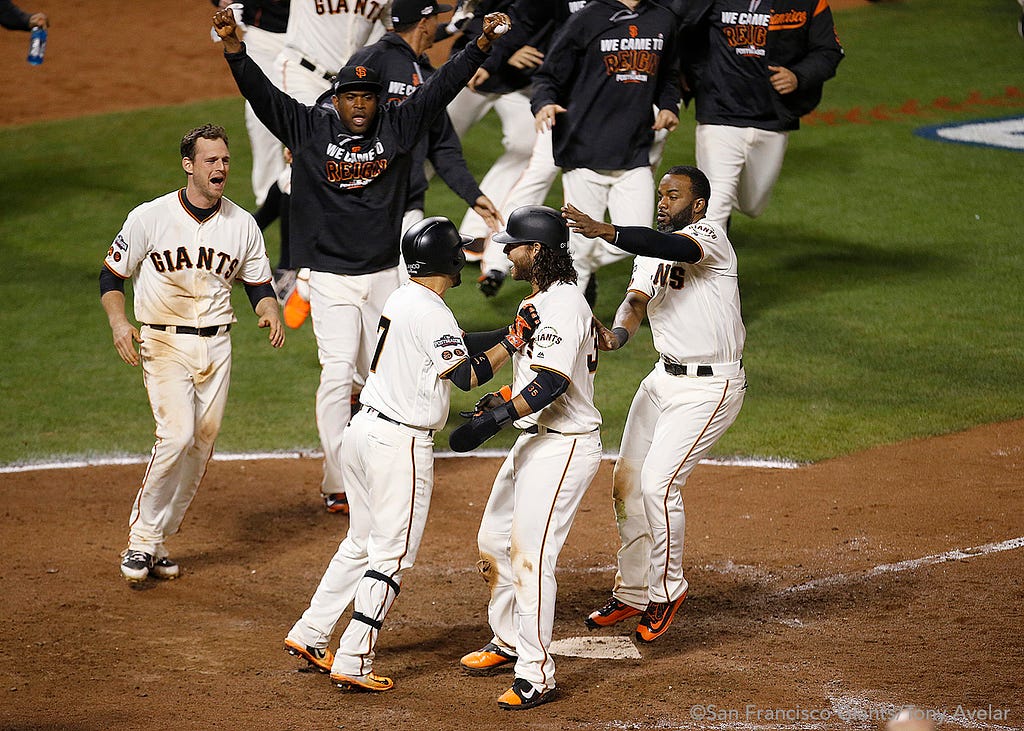 Brandon Crawford is greeted at home plate as he scores the winning run in the thirteenth inning.