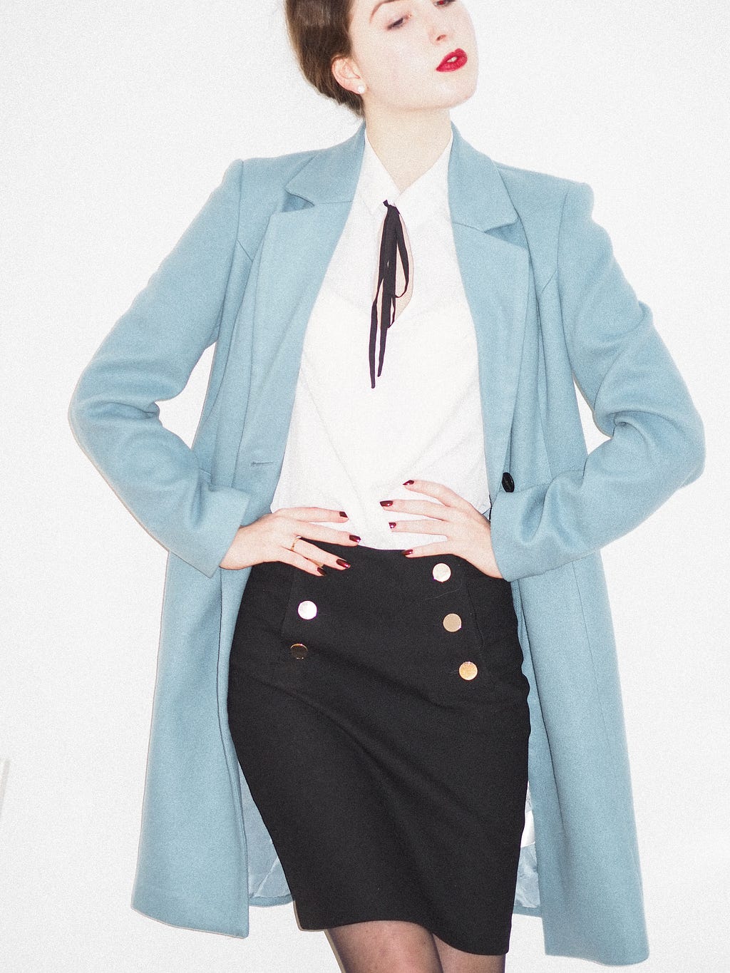 a confident young woman poses in a blue jacket