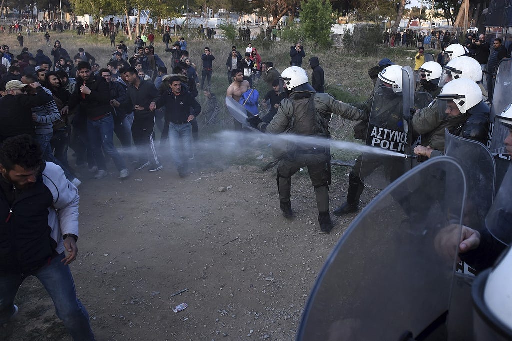 Riot police sprays tear gas toward protesting migrants during a rally outside a refugee camp in the village of Diavata, west of Thessaloniki, northern Greece, Thursday, April 4, 2019. Clashes broke out between migrants and Greek police outside a camp in northern Greece, where hundreds gathered following anonymous social media calls for a long trek through heavily guarded Balkan borders to seek asylum in Europe’s prosperous heartland. (AP Photo/Giannis Papanikos)