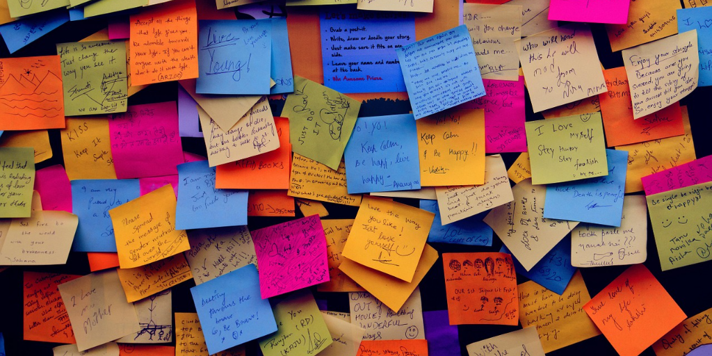 Wall covered in multicolored sticky notes with appreciative messages on them.