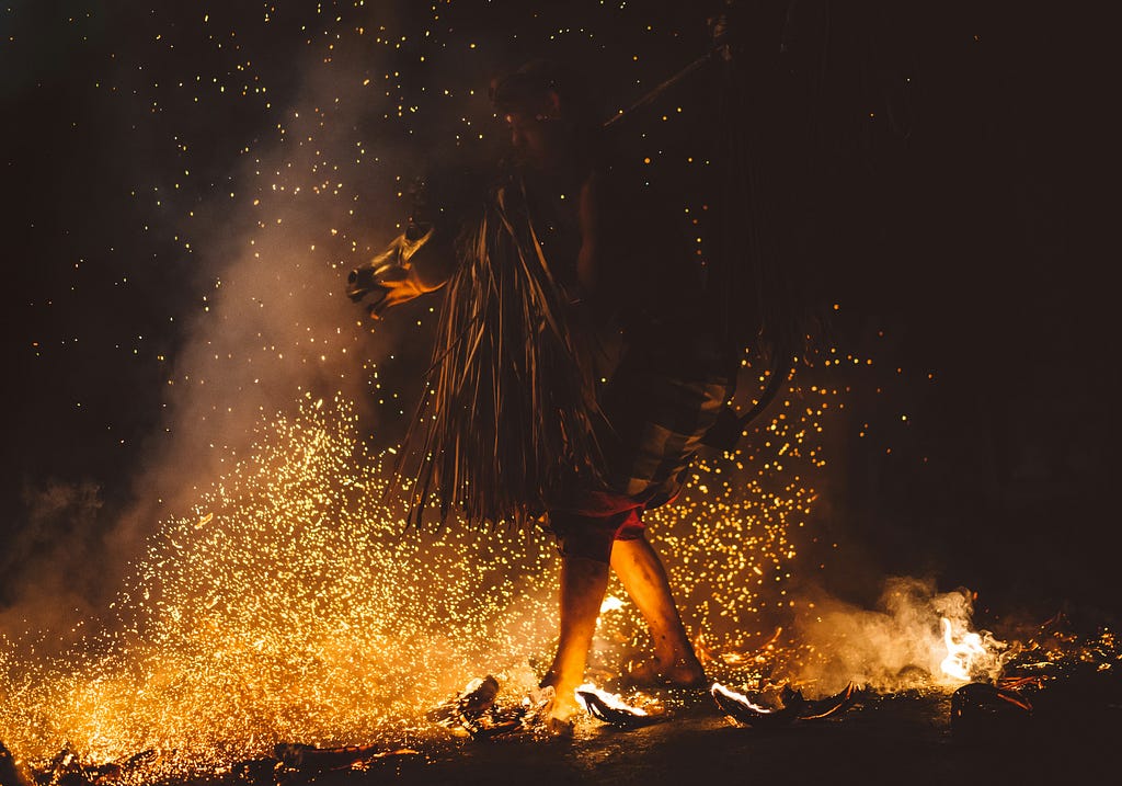 A costumed person walking on hot coals