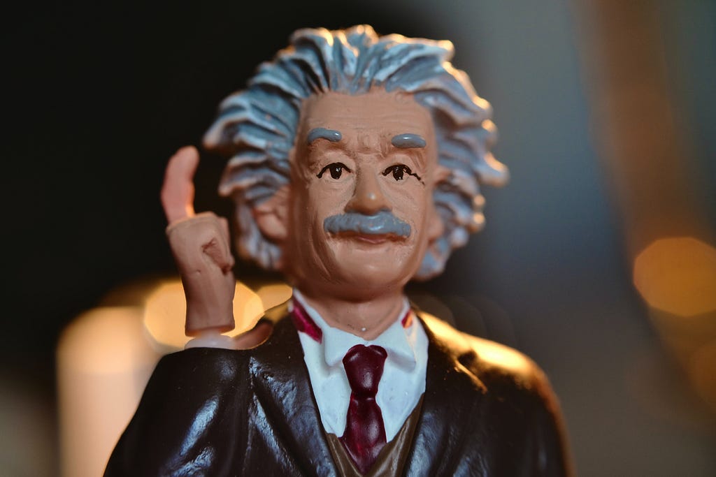 a model of einstein raising one finger as if having an idea