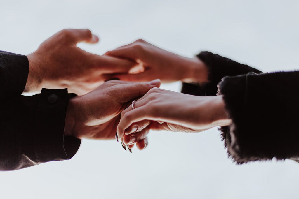 a close up of two sets of hand-holding. Is it two people, or four…?