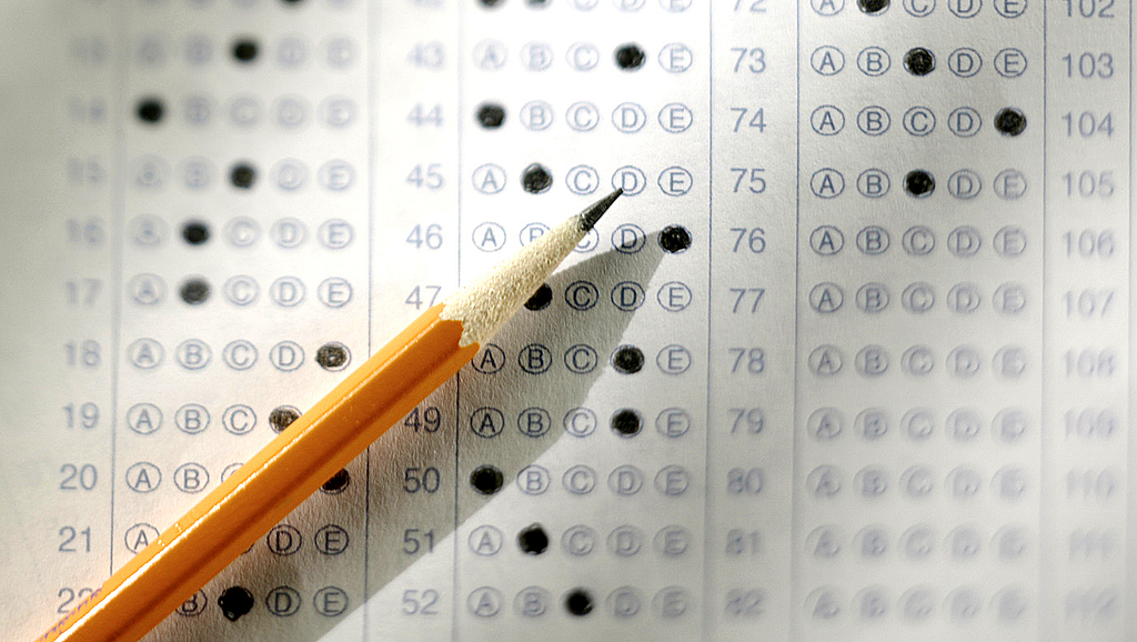 A wooden pencil laying on top off a filled-out scantron.