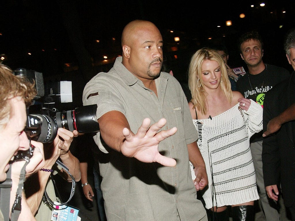 Britney Spears with a bodyguard at a fashion show in New York in 2003.