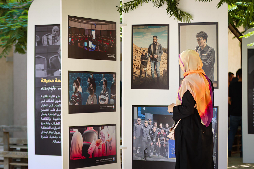 A woman gazes at a display of photographs taken by independent journalists.