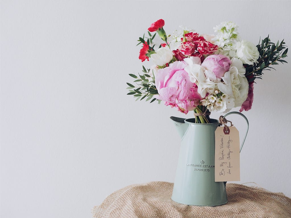 Bunch of pink and white flowers in a jug