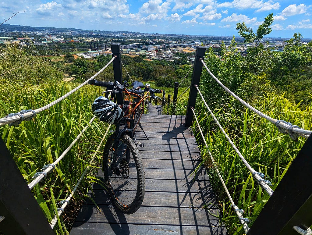 My bike on one of the step’s flat surfaces. The view of Wuri District behind.