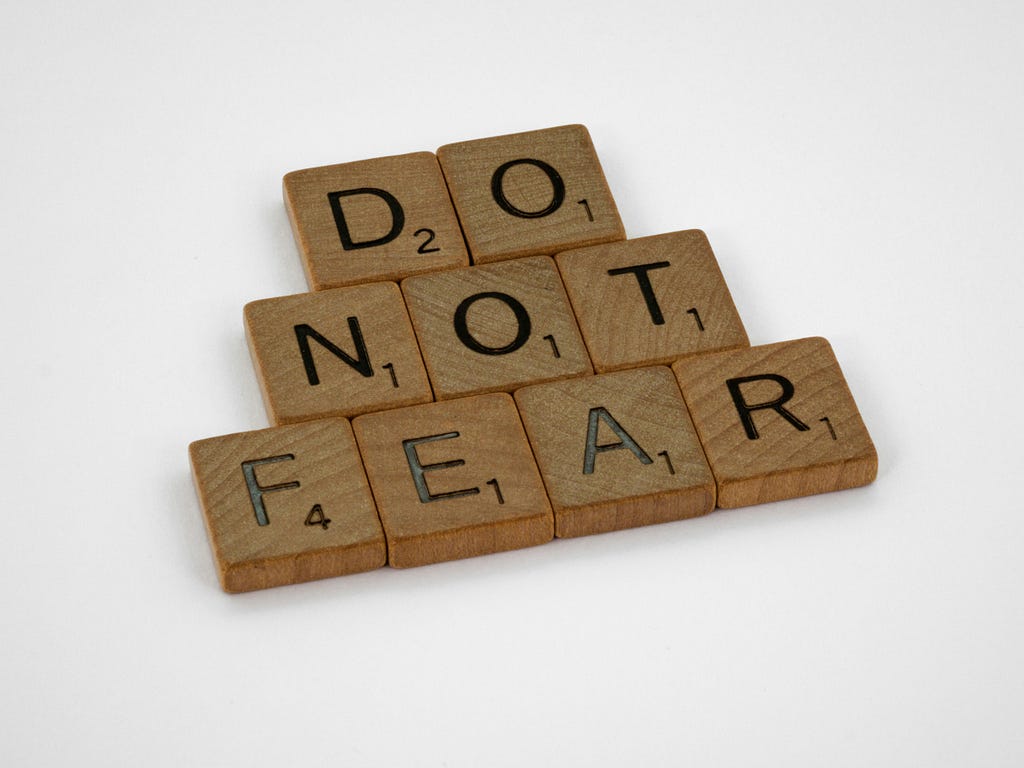 The letters from a Scrabble game spell out “DO NOT FEAR” with each word on top of the next word, which looks like a pyramid without a peak.