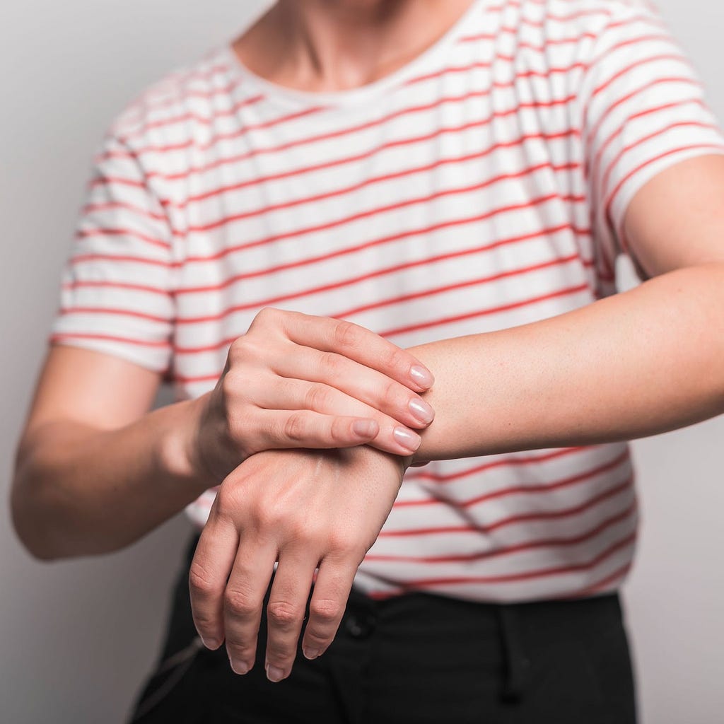 An image of an individual holding their wrist in pain.