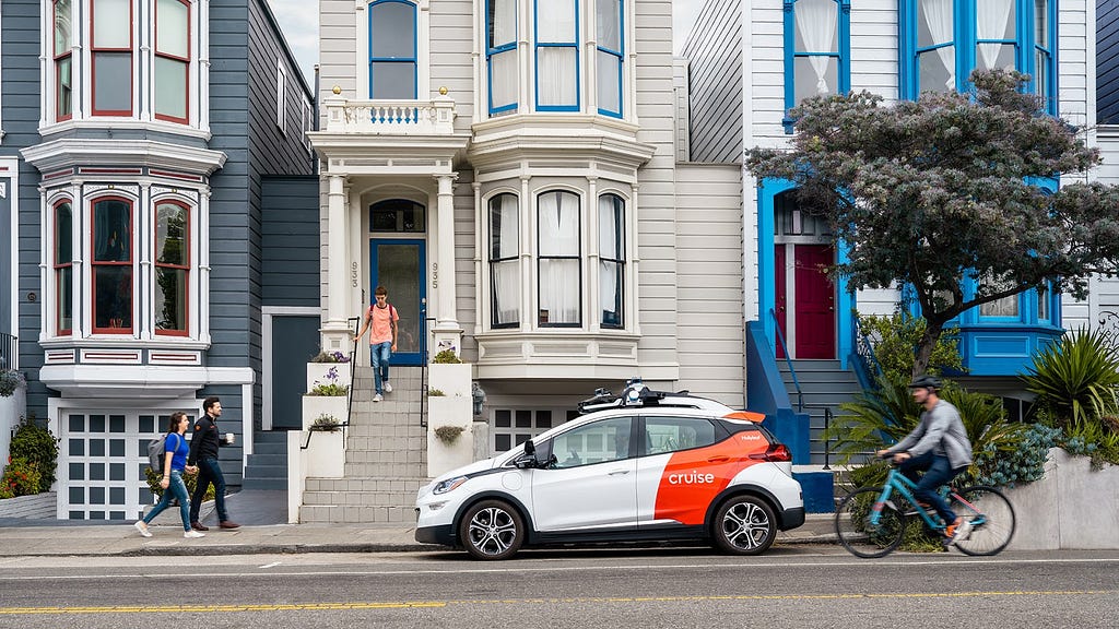 A Cruise autonomous vehicle drives through a quintessential San Francisco neighborhood surrounded by San Franciscans.