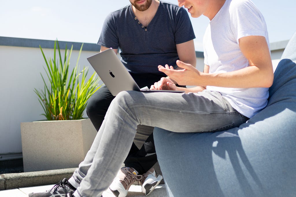 Two people chatting looking at a laptop