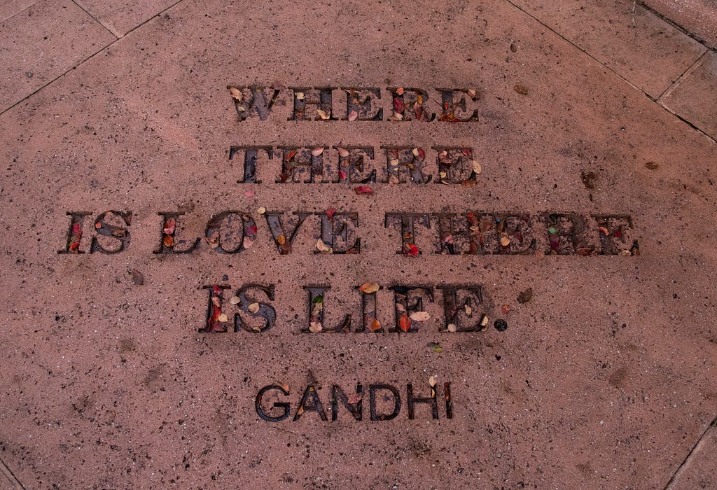 Imagem mostra uma inscrição no chão com a frase: Where there is love there is life (Gandhi)