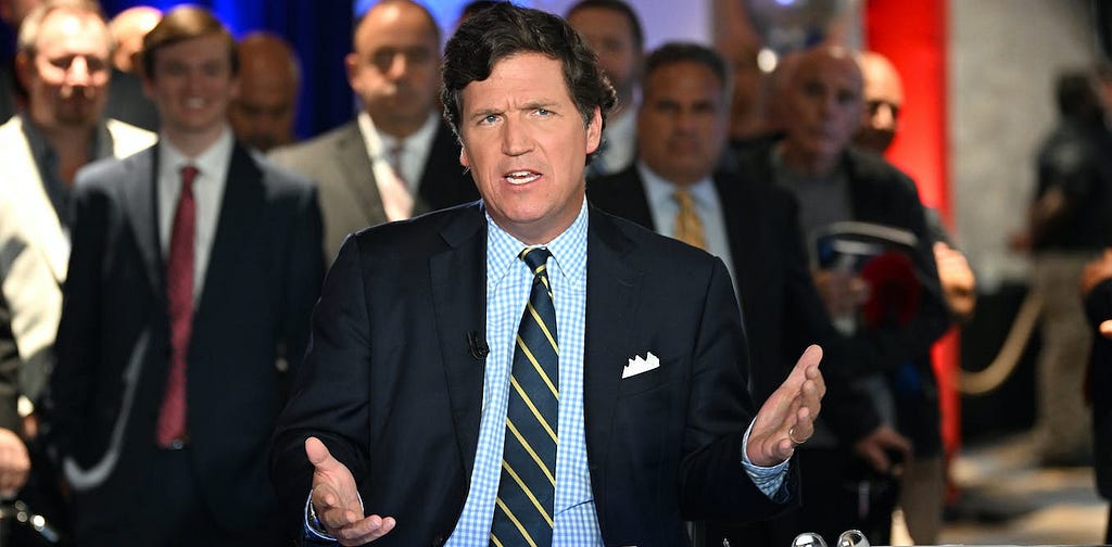 Carlson in a suit and striped tie, with a bunch of men in suits behind him