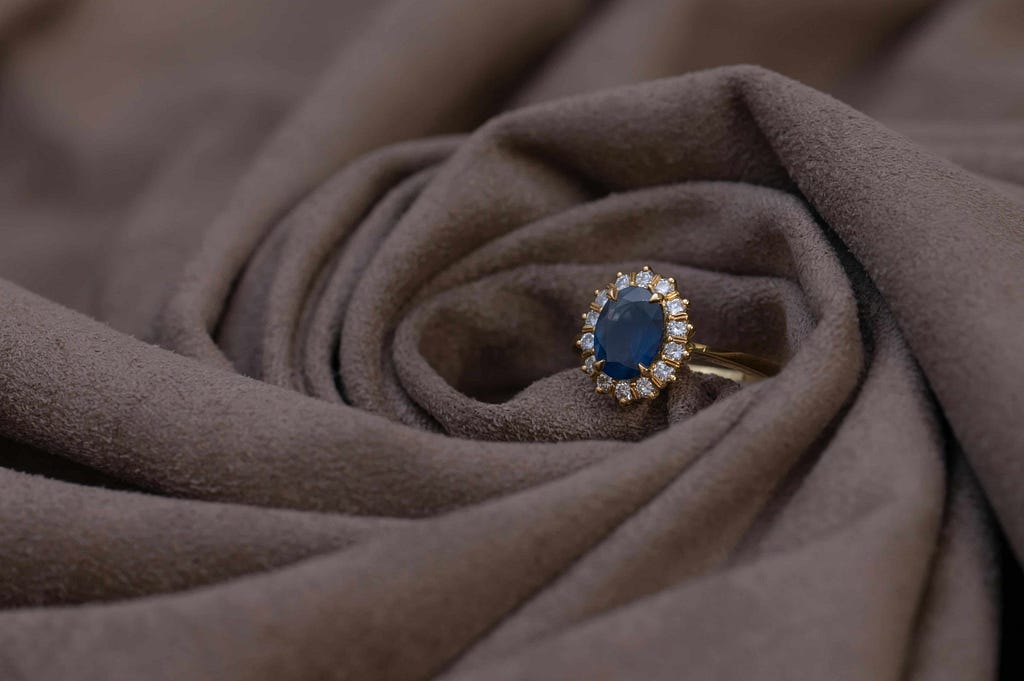 A sapphire engagement ring with a halo of diamonds, showcasing the elegance of oval cut diamond rings, perfect for everyday wear.