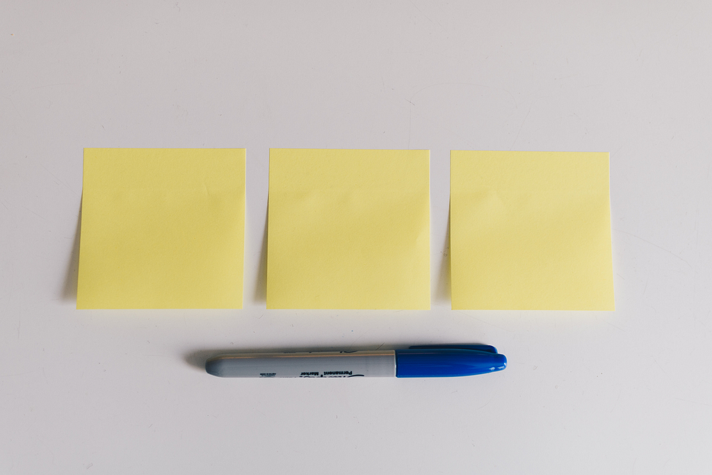 Three post-its side by side with a marker underneath them.