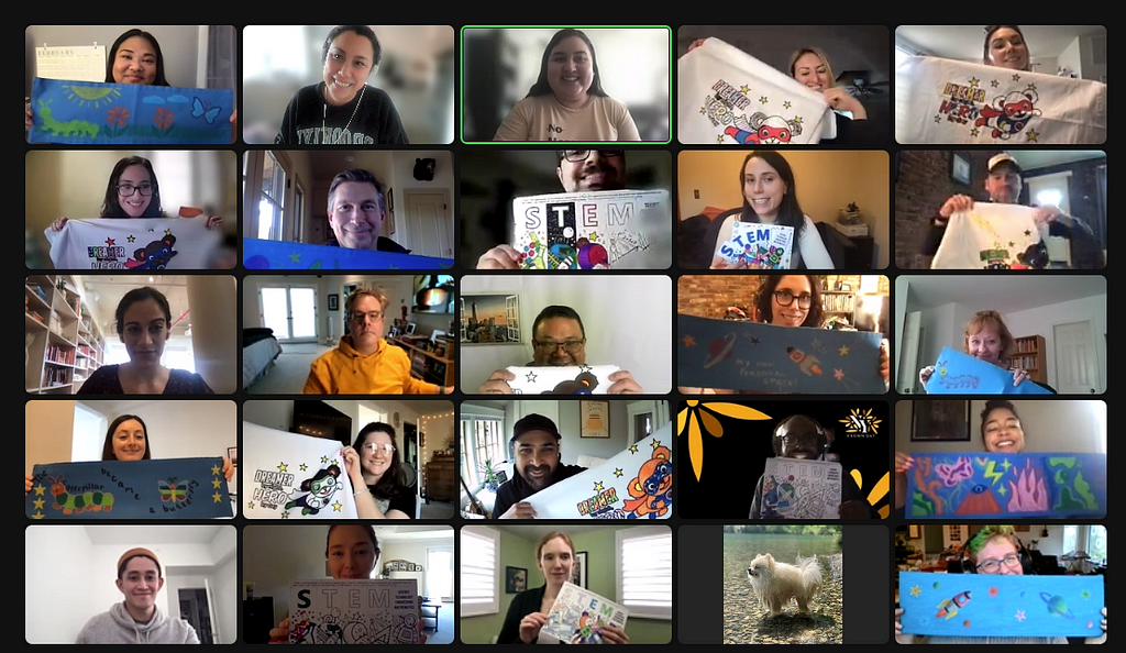 Screenshot shows a Zoom gallery of people holding up art projects