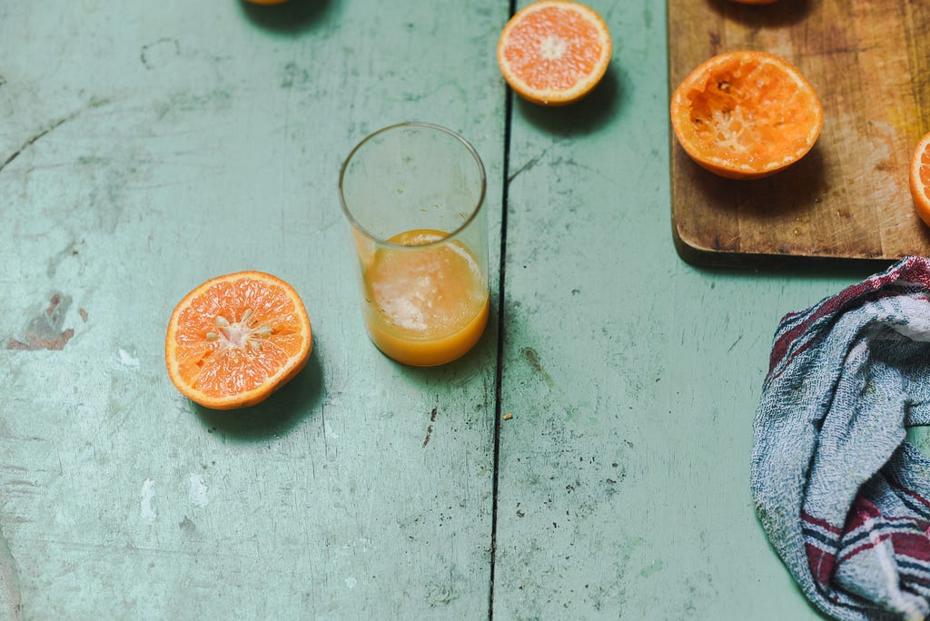 A glass of freshly squeezed orange juice on a wooden table