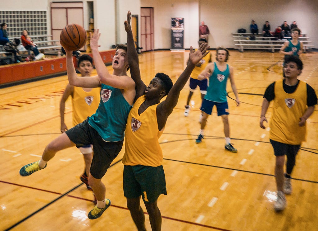 Two teams playing a basketball match (blue and yellow)