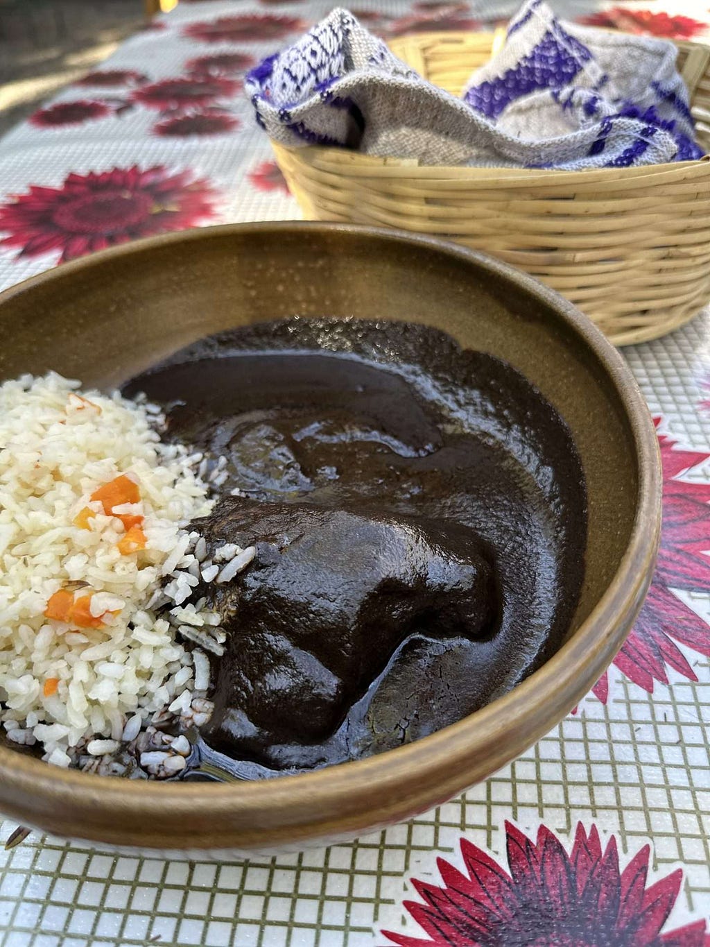 A bowl of chicken mole and rice on a table at a restaurant called Almu in Oaxaca