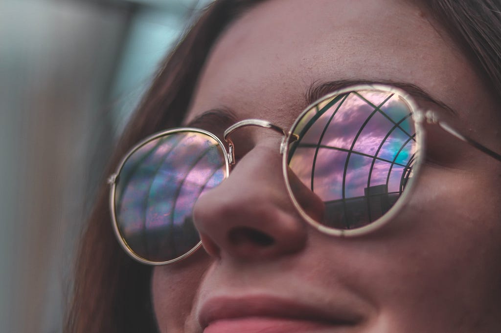 Be mindful of euphoric recall during a sober summer: woman wearing reflective tinted glasses