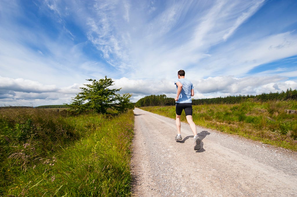 Person running alone on a long road with no clear destination