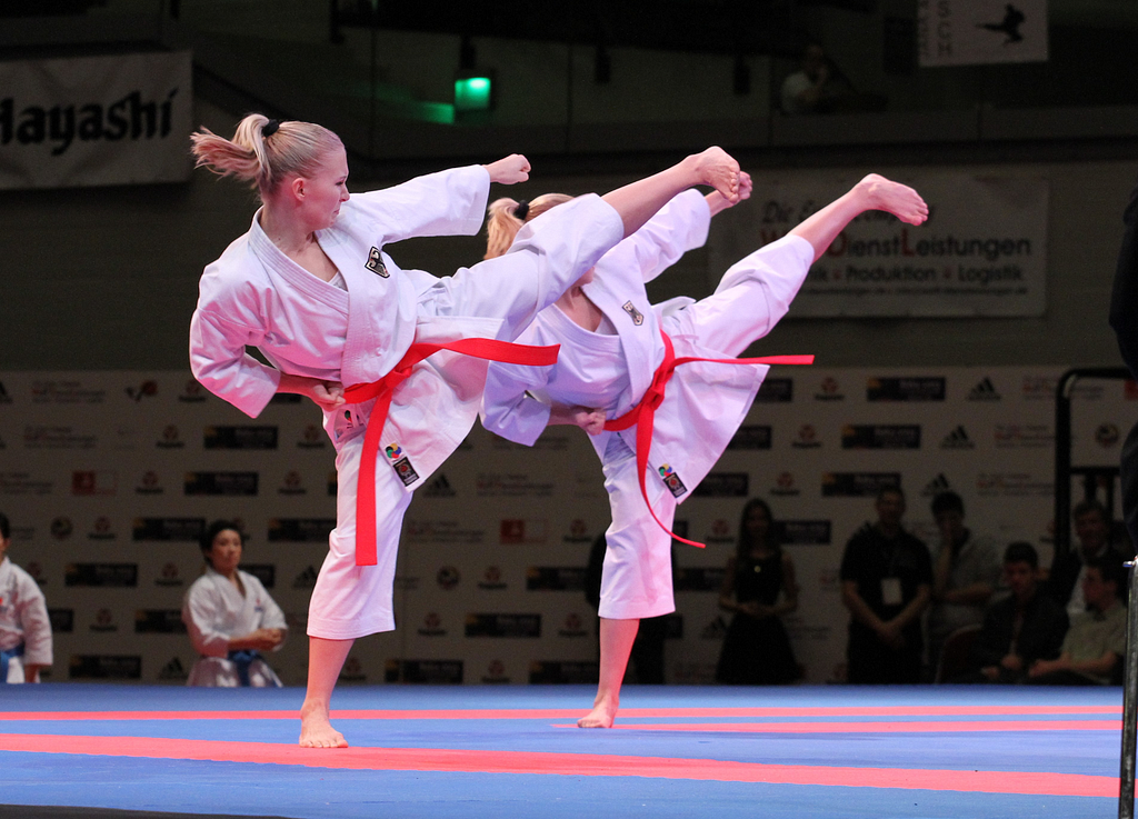 Two women kicking during a karate tournament