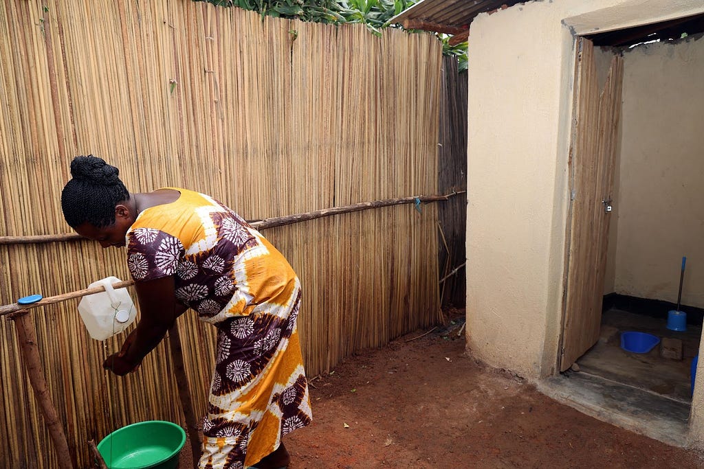 Vestine Mukantwaza uses a homemade handwashing facility after using the toilet.